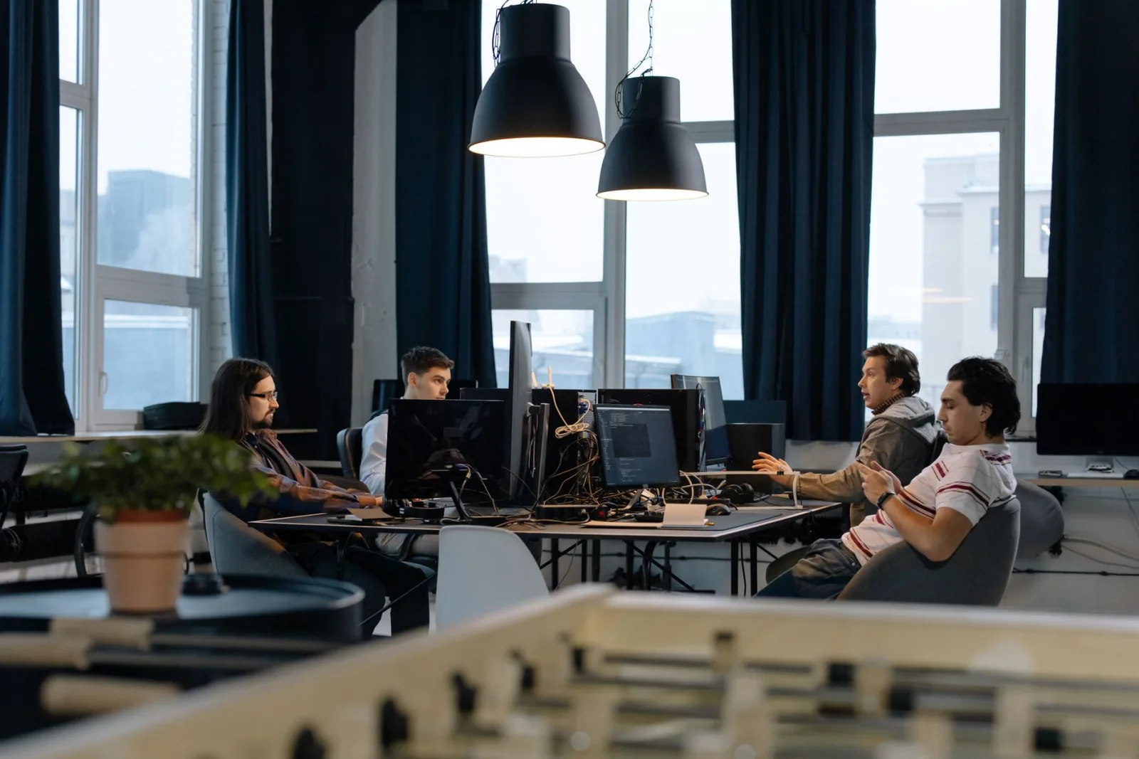 Équipe d'une jeune entreprise au travail sur des ordinateurs dans un open space lumineux