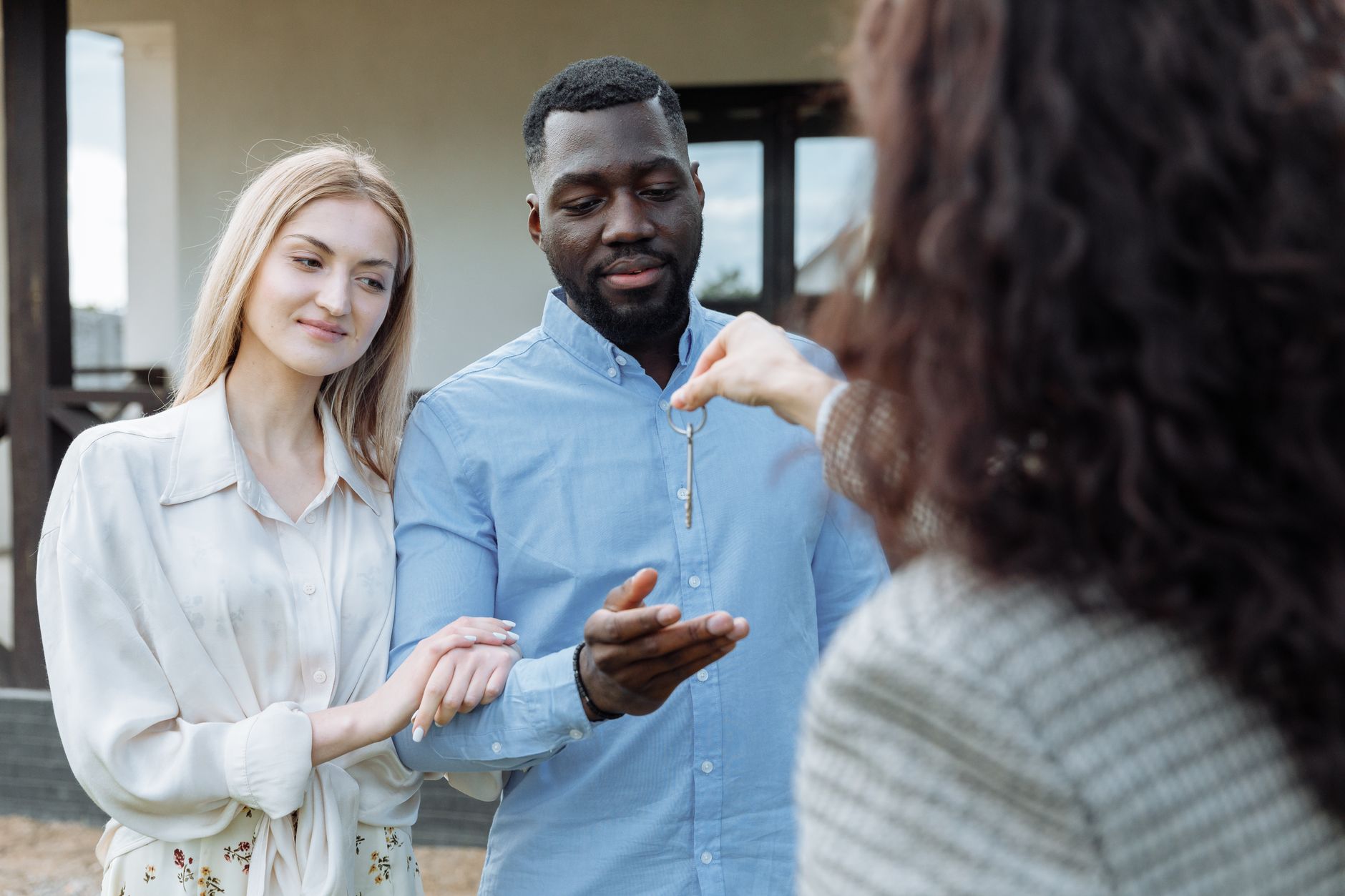 Jeune couple recevant les clés de sa nouvelle maison, illustrant l'accession via un prêt à taux zéro